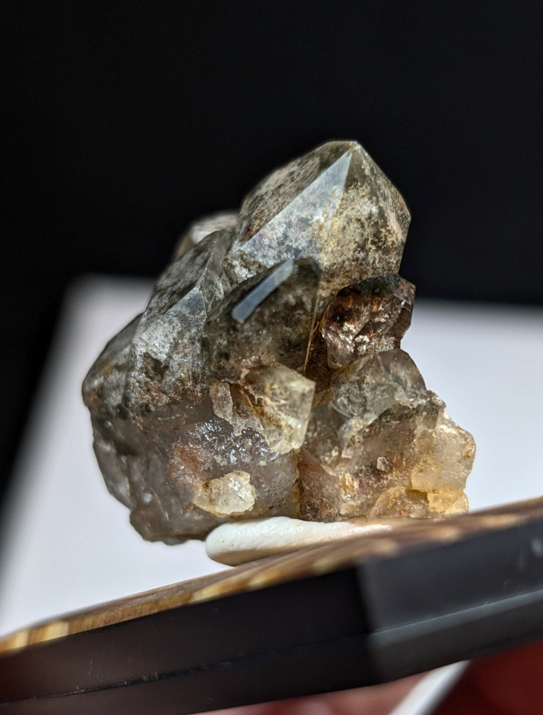 A translucent, earthy-toned quartz crystal cluster with a rough, jagged surface and subtle golden inclusions.