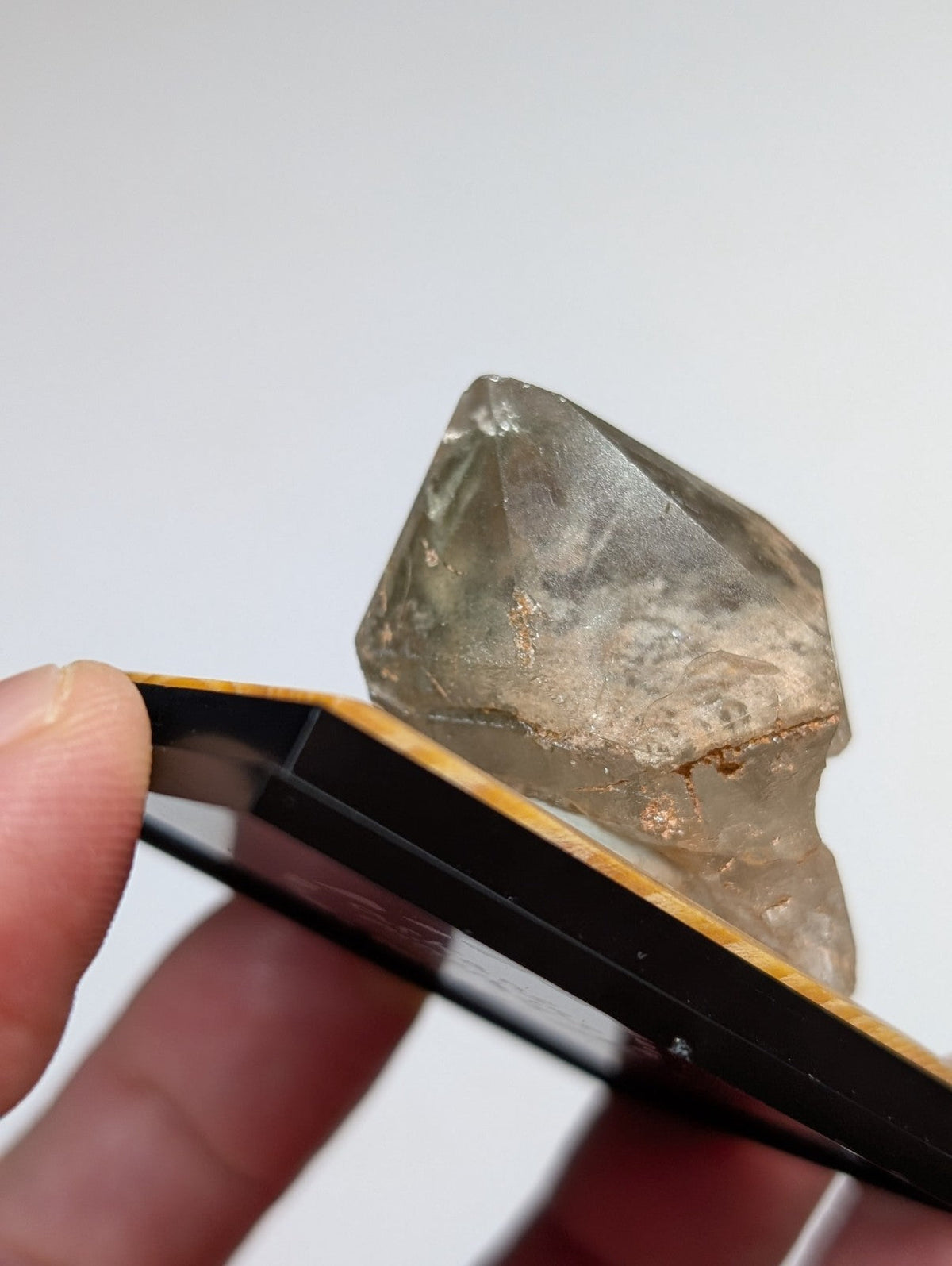 A translucent, faceted quartz crystal with a pale yellowish tint and natural mineral inclusions.