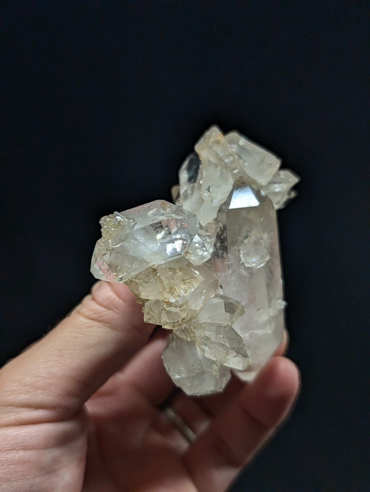 A translucent, clear quartz crystal cluster with a mix of sharp-edged and rounded facets.