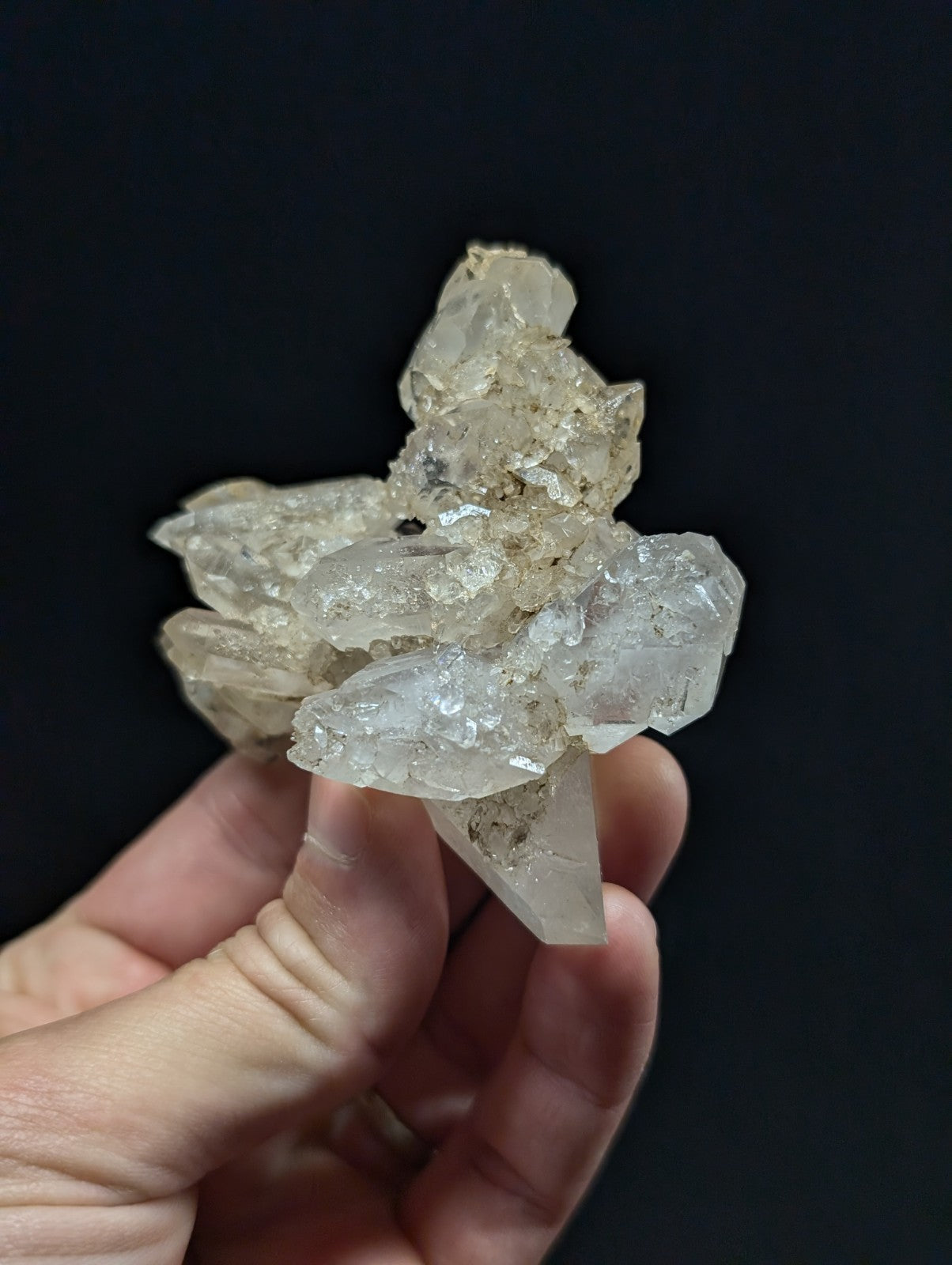 A translucent, crystalline quartz cluster with jagged edges and a pale, milky-white hue.