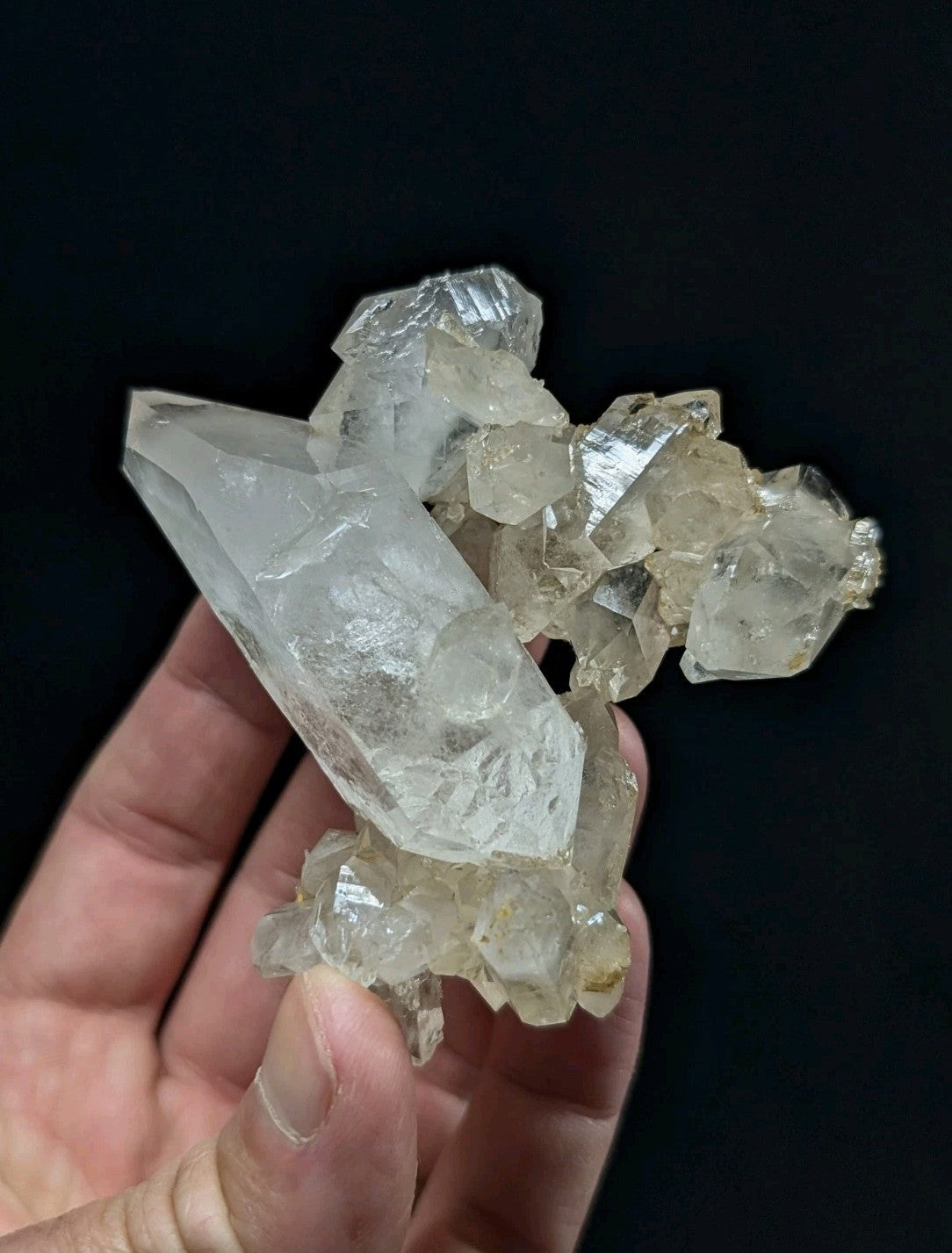 A translucent, crystalline quartz cluster with sharp facets and a pale yellowish tint.