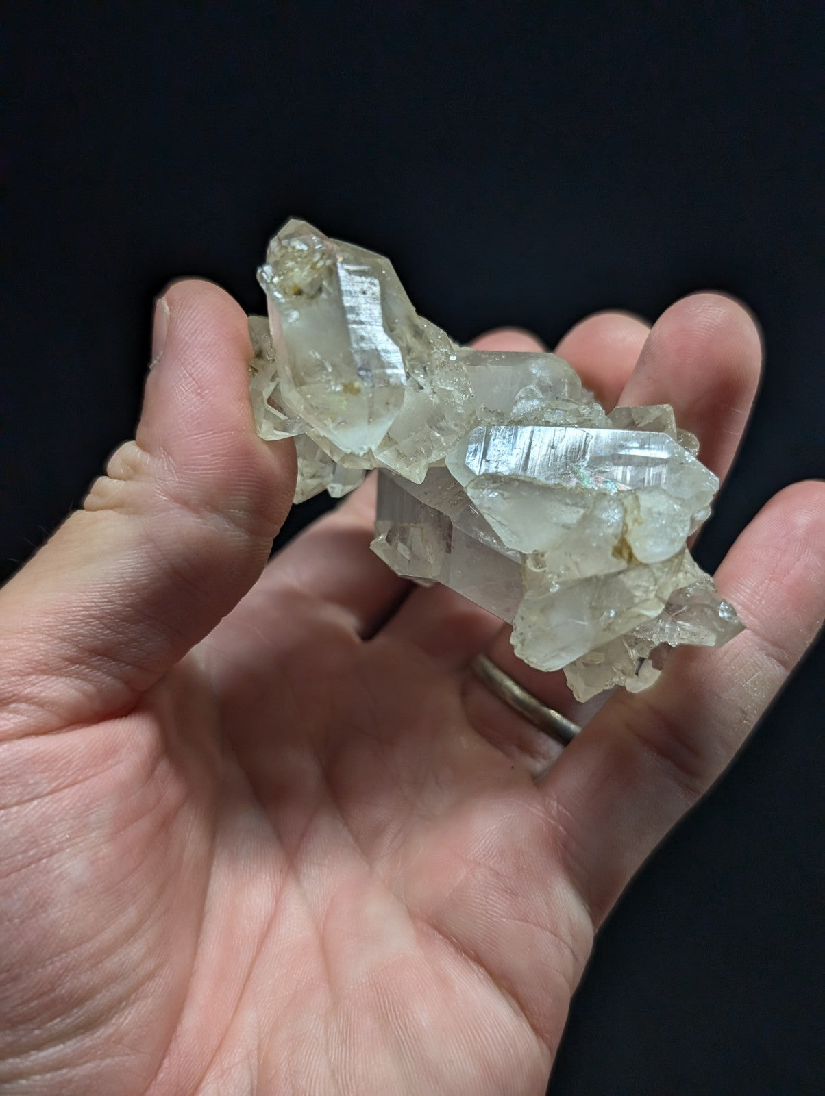 A translucent, pale quartz crystal cluster with sharp, faceted edges and subtle internal striations.
