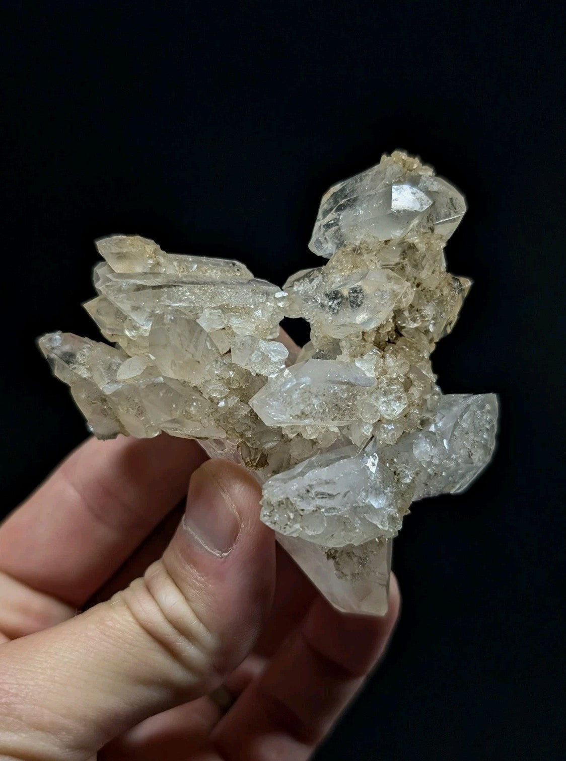 A translucent, pale yellowish quartz crystal cluster with sharp facets and a natural, earthy matrix.