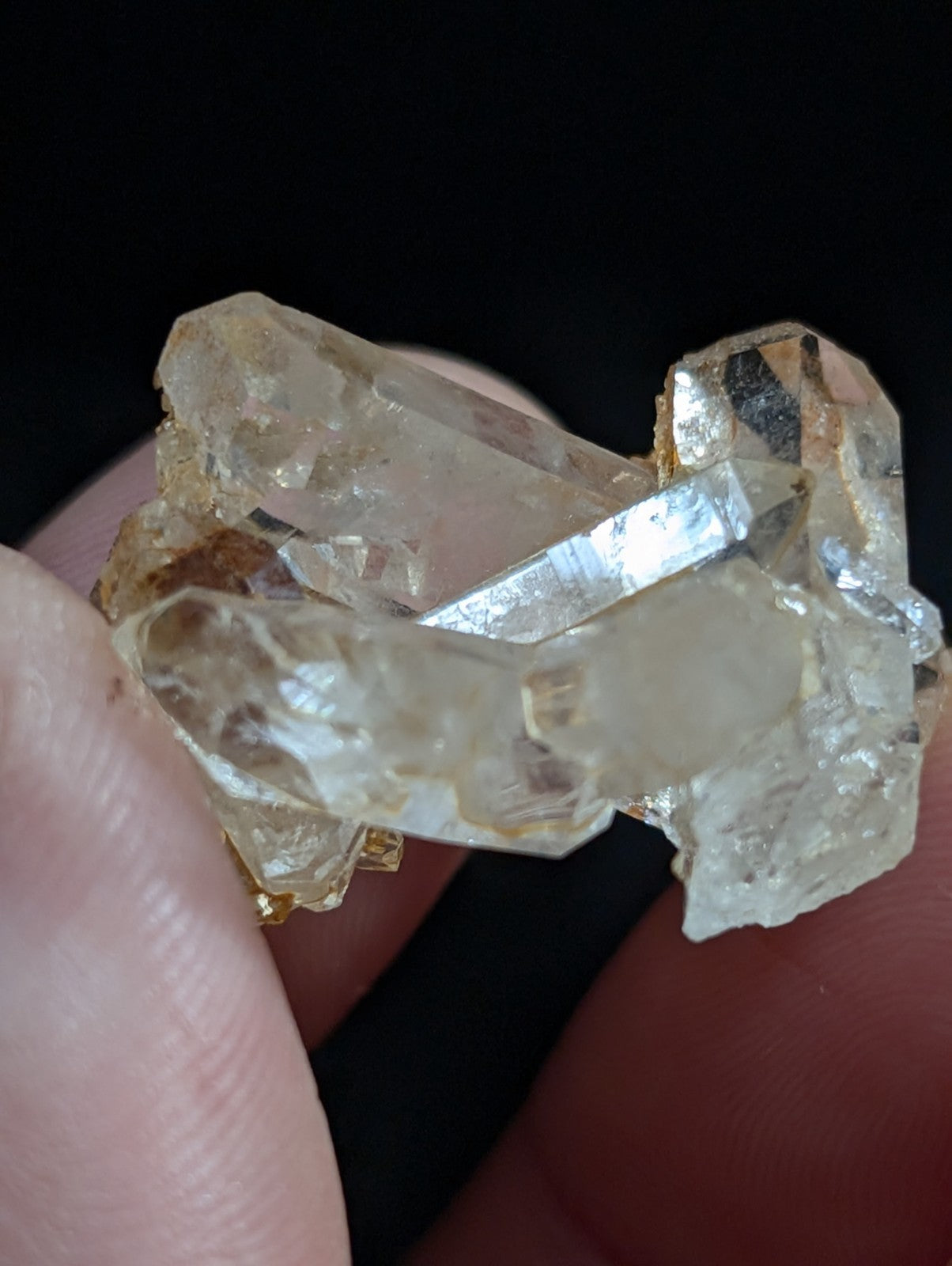 A cluster of translucent, pale yellowish quartz crystals with sharp facets and natural imperfections.