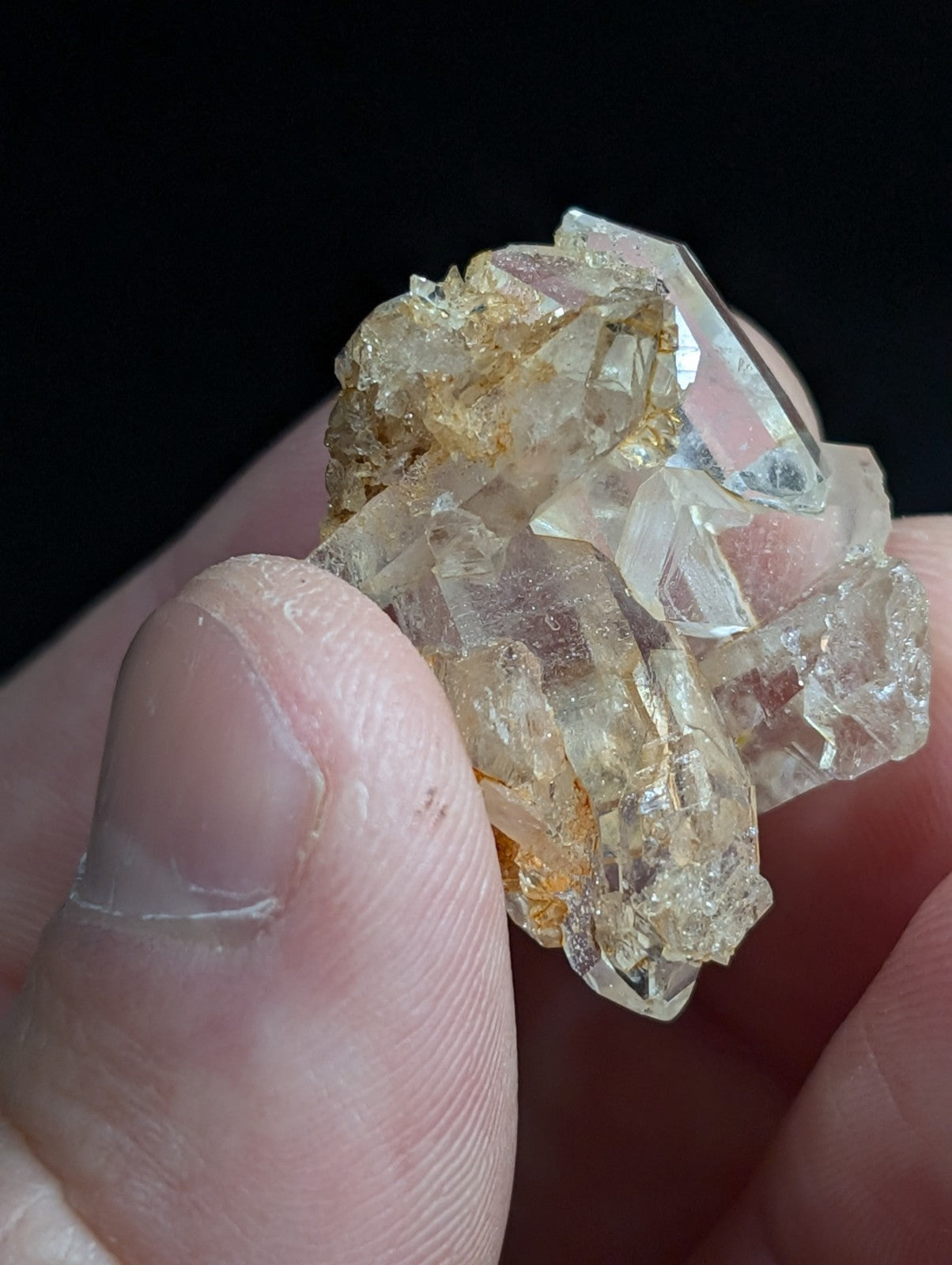 A cluster of translucent, golden-hued quartz crystals with sharp facets and a natural, irregular formation.