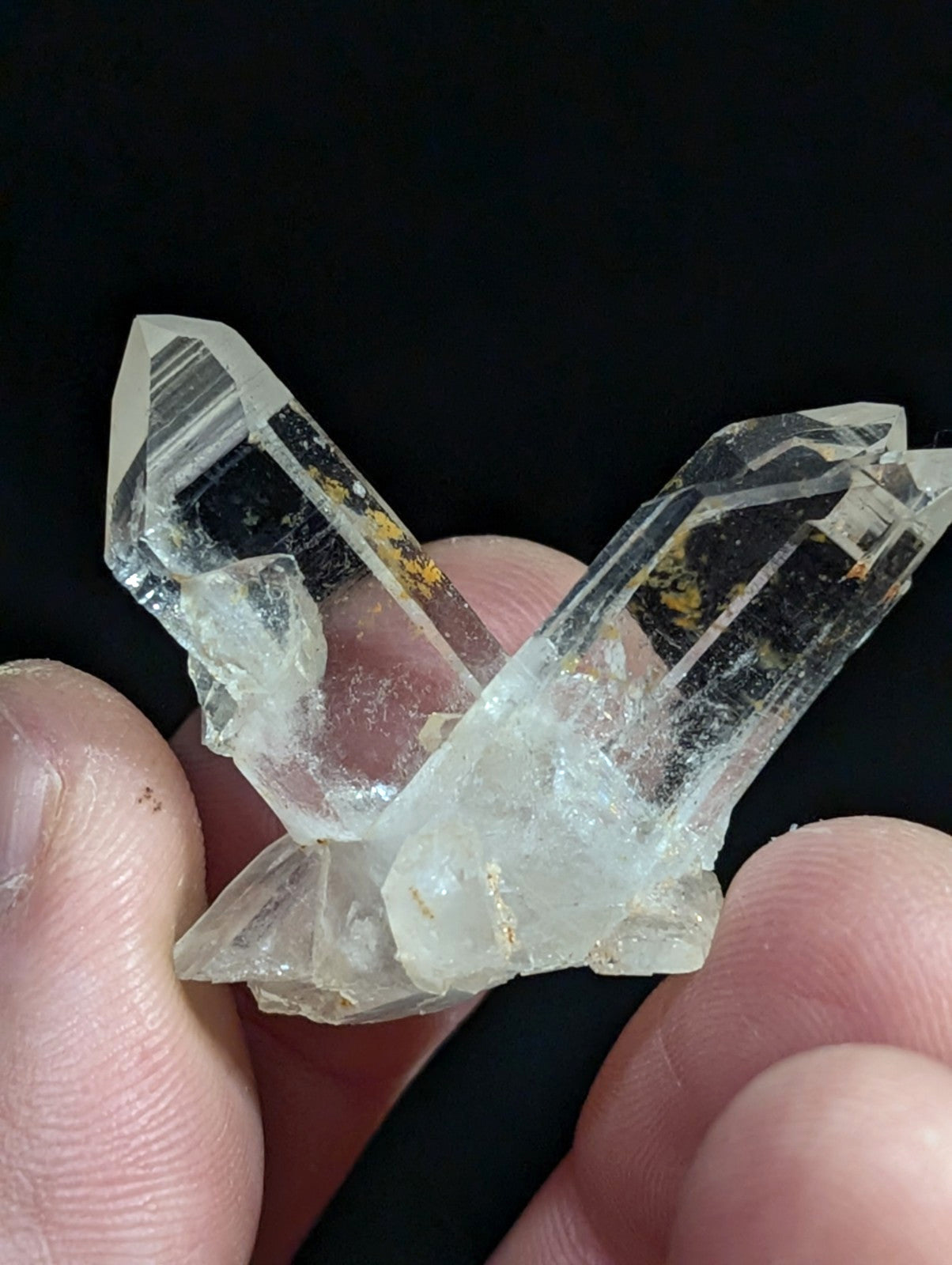 A clear quartz crystal cluster with two prominent, pointed prisms intersecting at a base.
