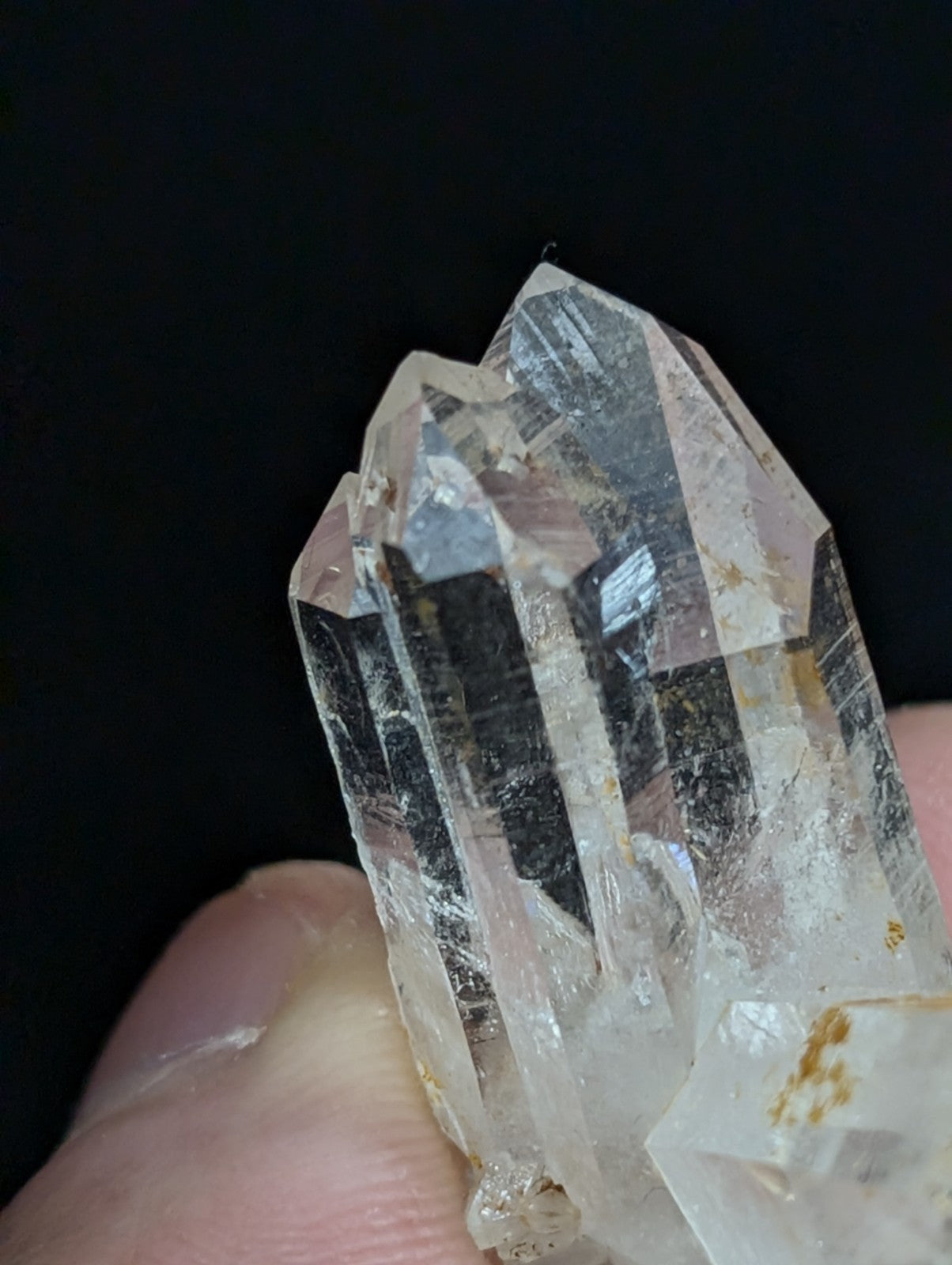 A clear, translucent quartz crystal cluster with sharp geometric facets and subtle golden inclusions.