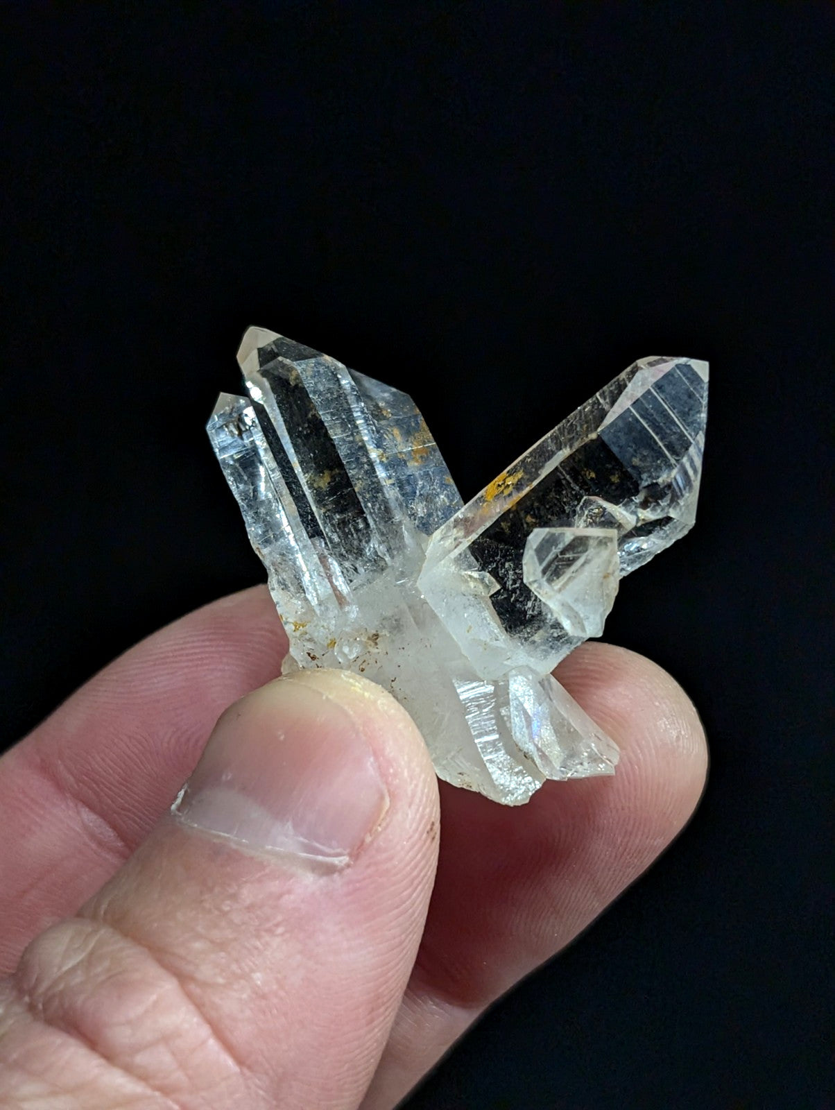 A clear, translucent quartz crystal cluster with sharp facets and subtle internal inclusions.