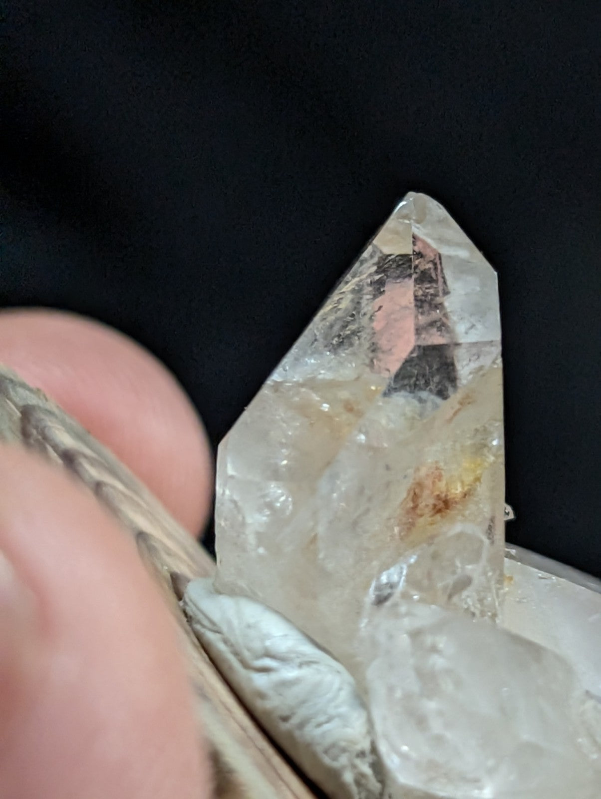 A clear quartz crystal cluster with a pointed, faceted top and subtle internal inclusions.
