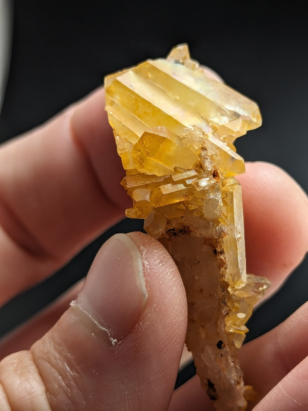 A cluster of translucent golden-yellow crystal formations with sharp, angular facets and a slightly rough base.
