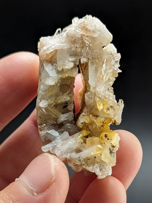 A translucent, crystalline mineral specimen with a mix of clear and golden-yellow crystals forming an irregular, natural shape.