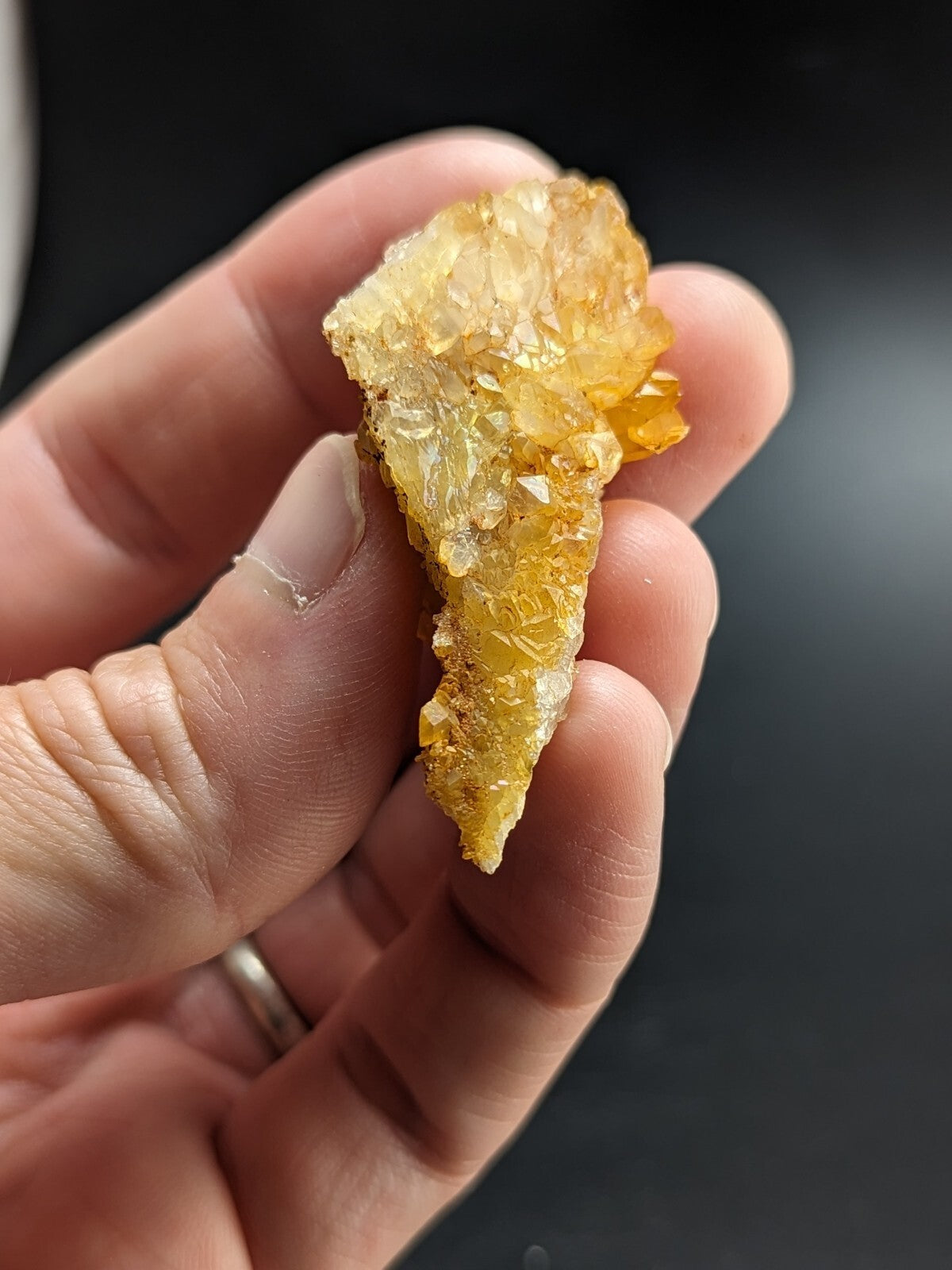 A translucent golden-yellow crystal cluster with a rough, jagged surface and visible facets.