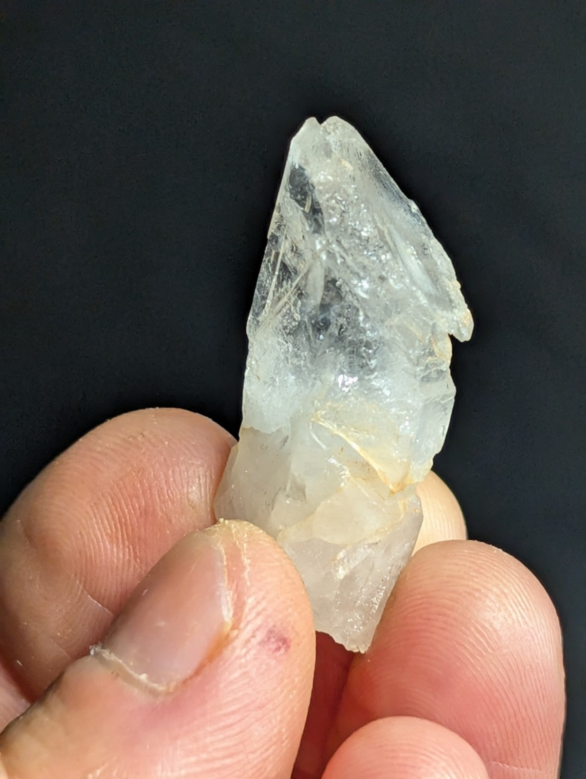 A translucent, pale quartz crystal with jagged edges and a slightly cloudy base.