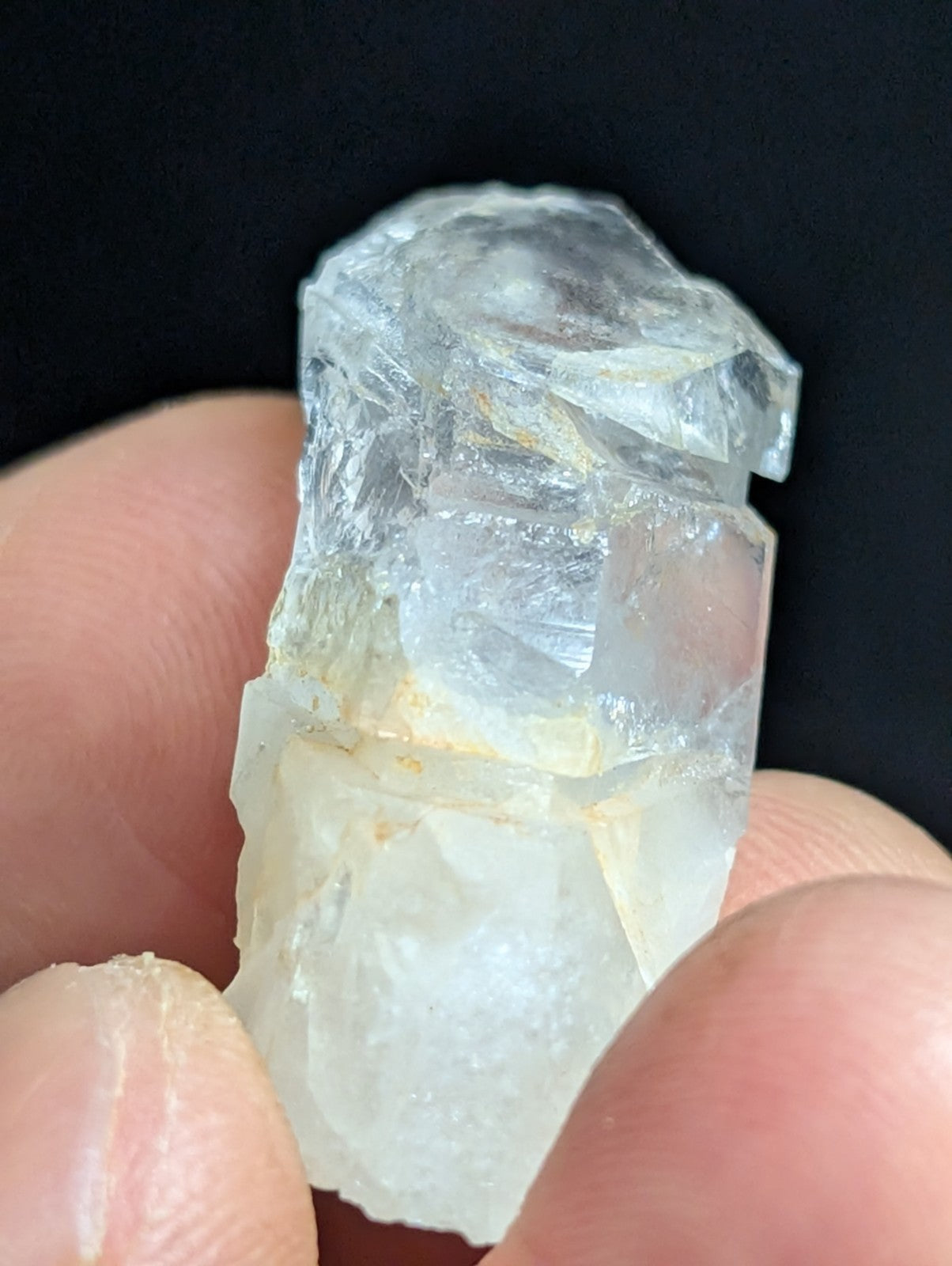 A translucent, clear quartz crystal with jagged edges and a slightly yellowish tint near its base.