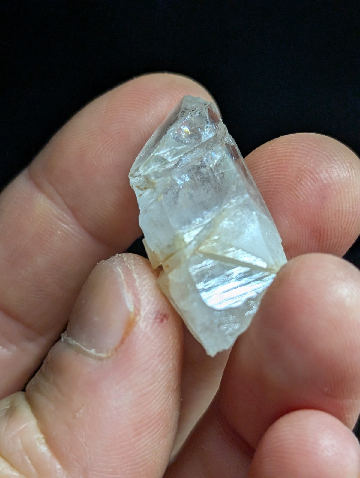 A translucent, faceted crystal fragment with a pale blue tint and visible internal inclusions.