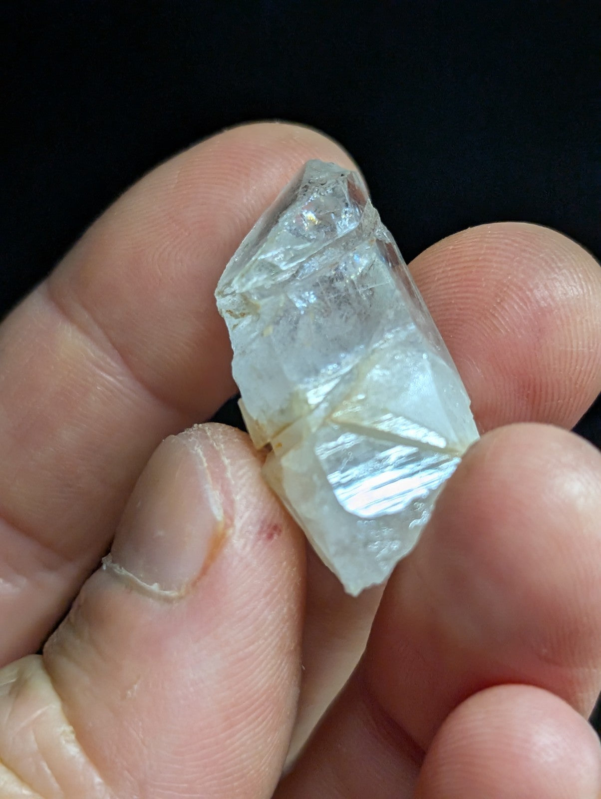 A translucent, faceted crystal fragment with a pale blue tint and visible internal inclusions.