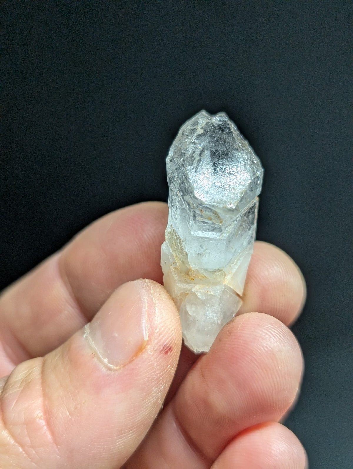 A translucent, pale blue quartz crystal with a rough, faceted surface and natural imperfections.
