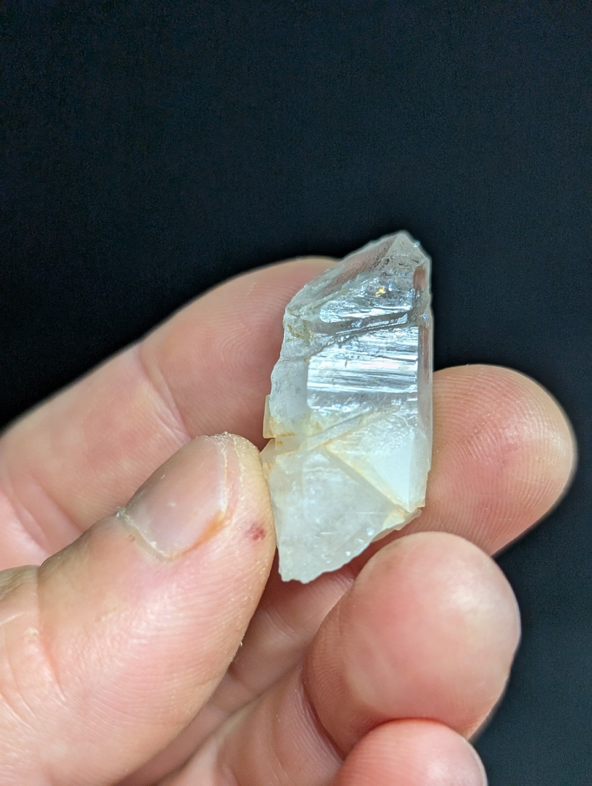 A translucent, pale quartz crystal with visible internal striations and a slightly jagged, natural edge.