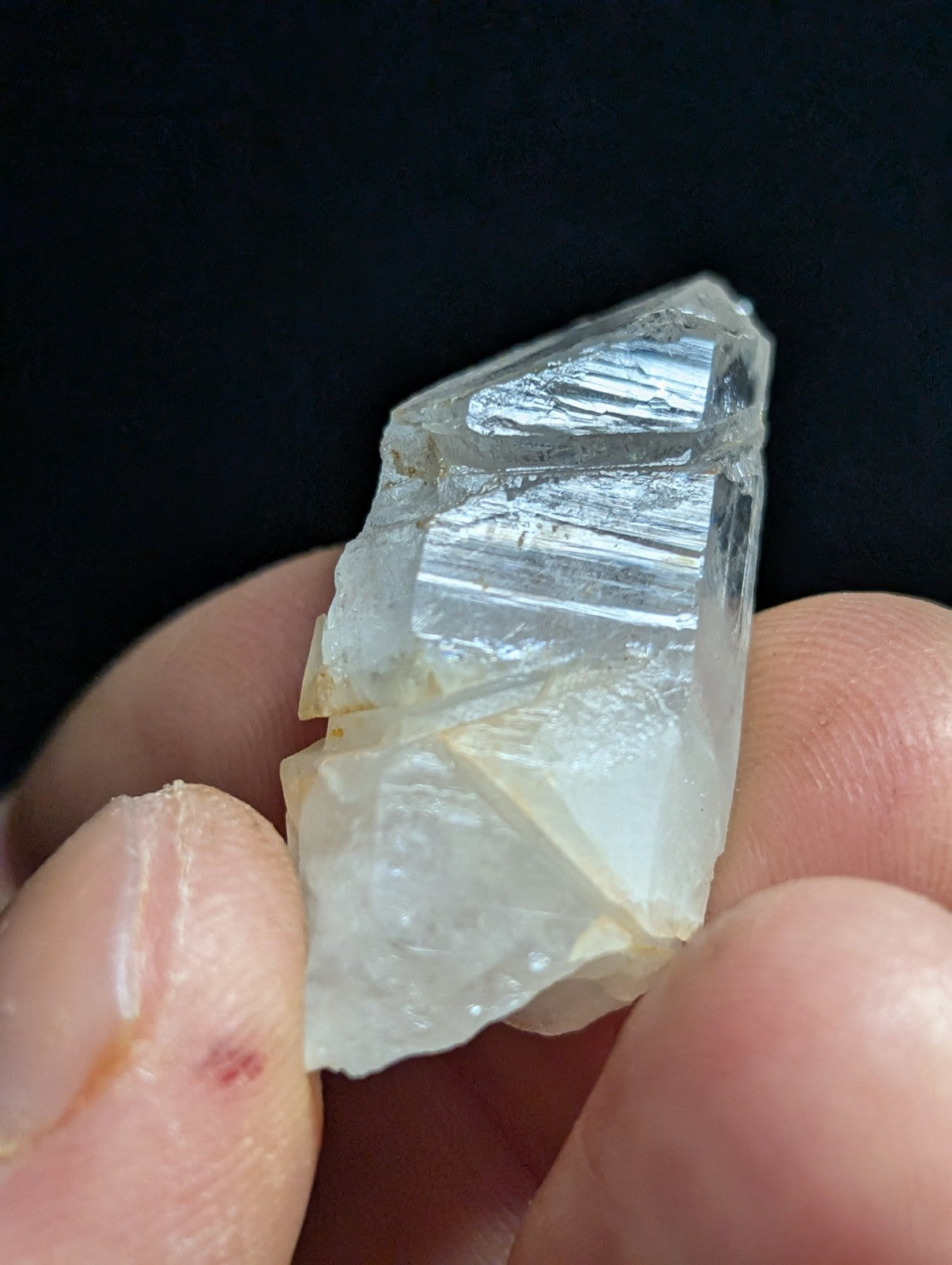 A translucent, pale quartz crystal with visible internal striations and a slightly rough, jagged surface.