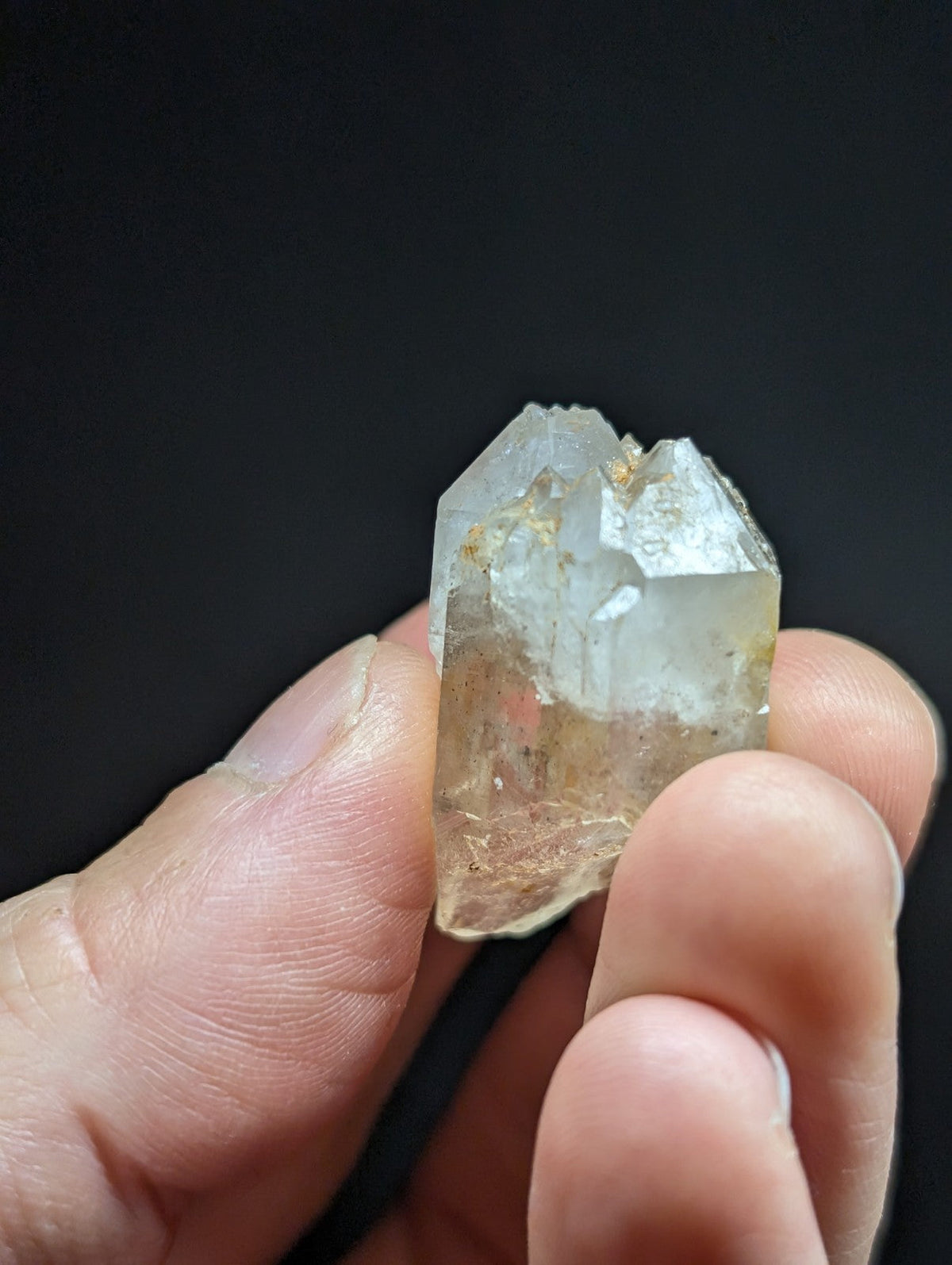 A translucent, pale yellowish quartz crystal with a rough, jagged surface and subtle golden inclusions.