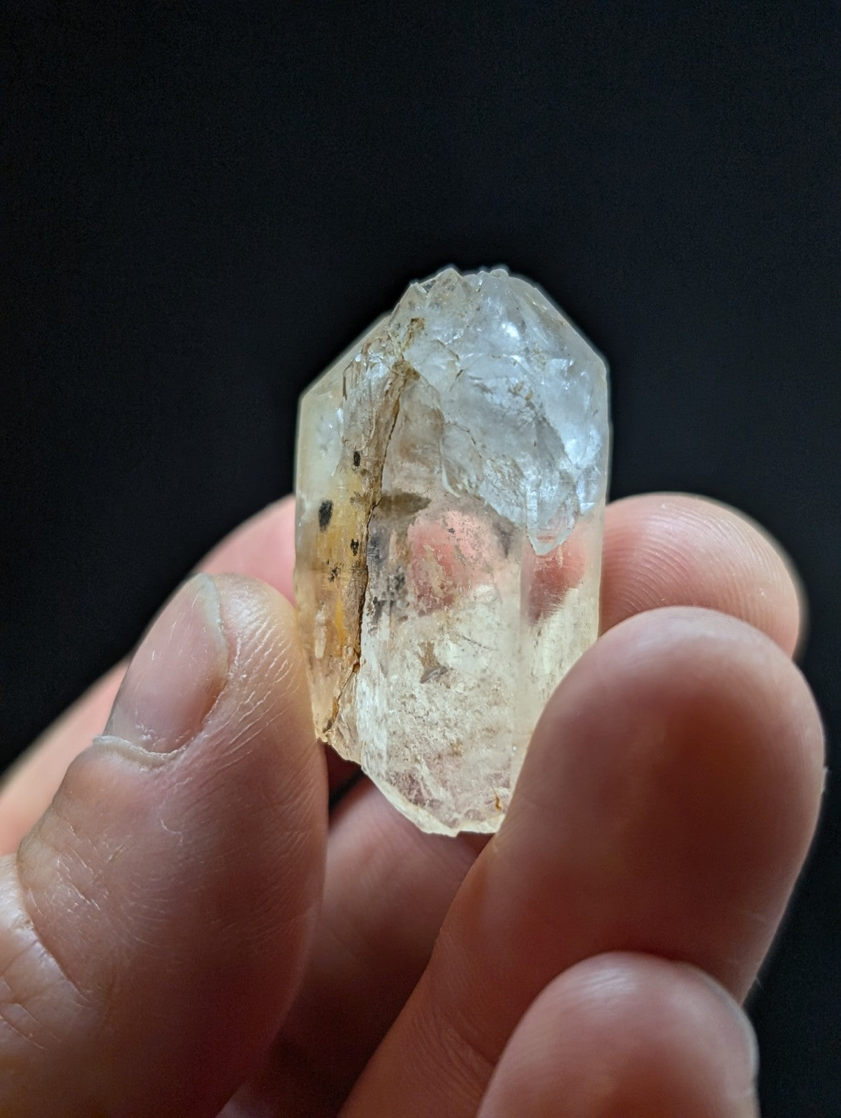 A translucent, pale yellowish quartz crystal with visible internal inclusions and a rough, faceted surface.