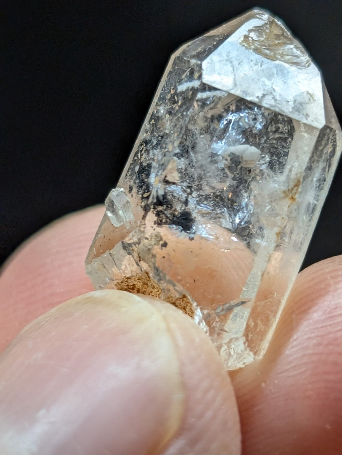 A clear, faceted quartz crystal with natural inclusions and a slightly rough texture.