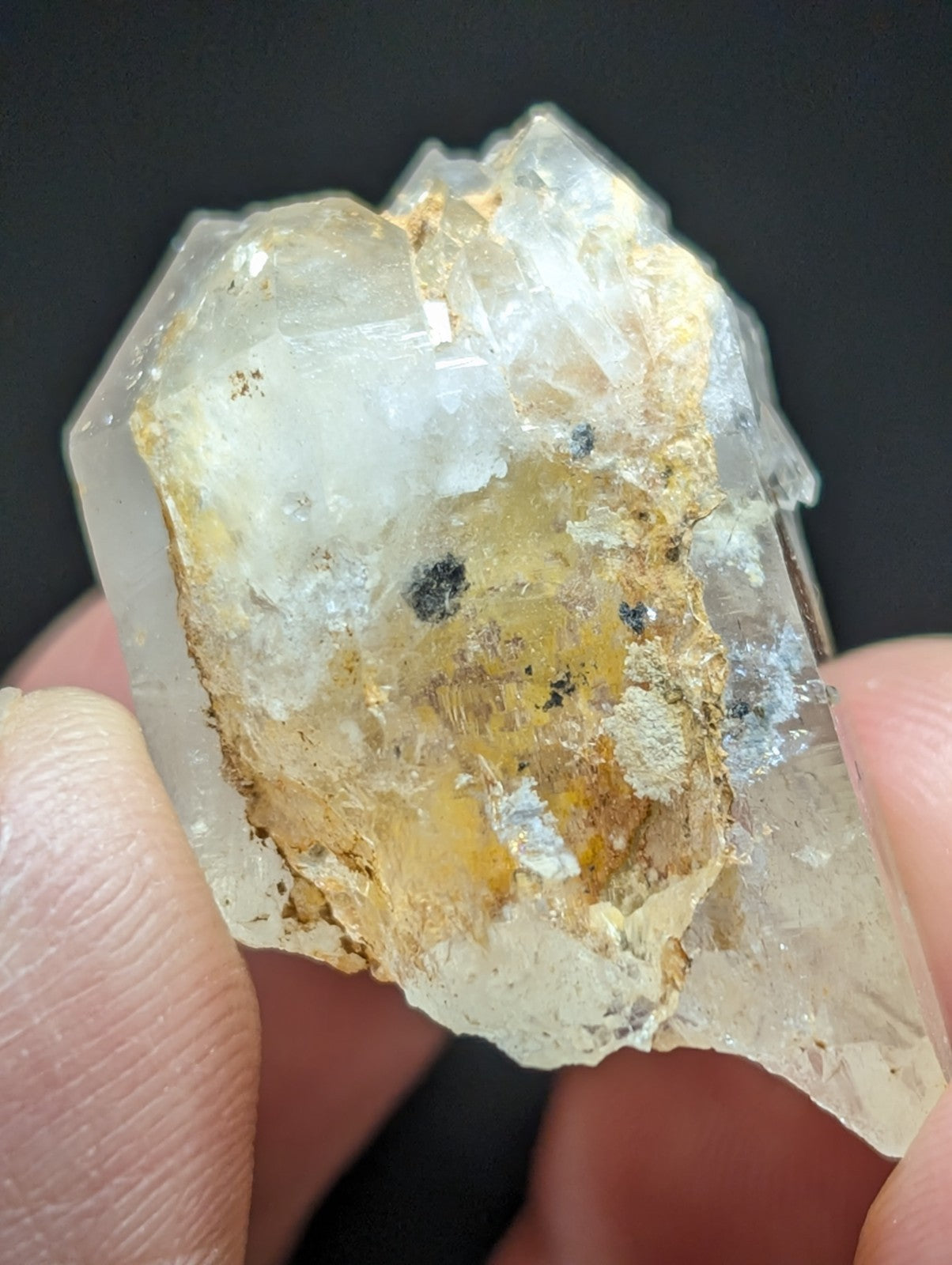 A translucent quartz crystal with golden-yellow inclusions and a rough, jagged surface.