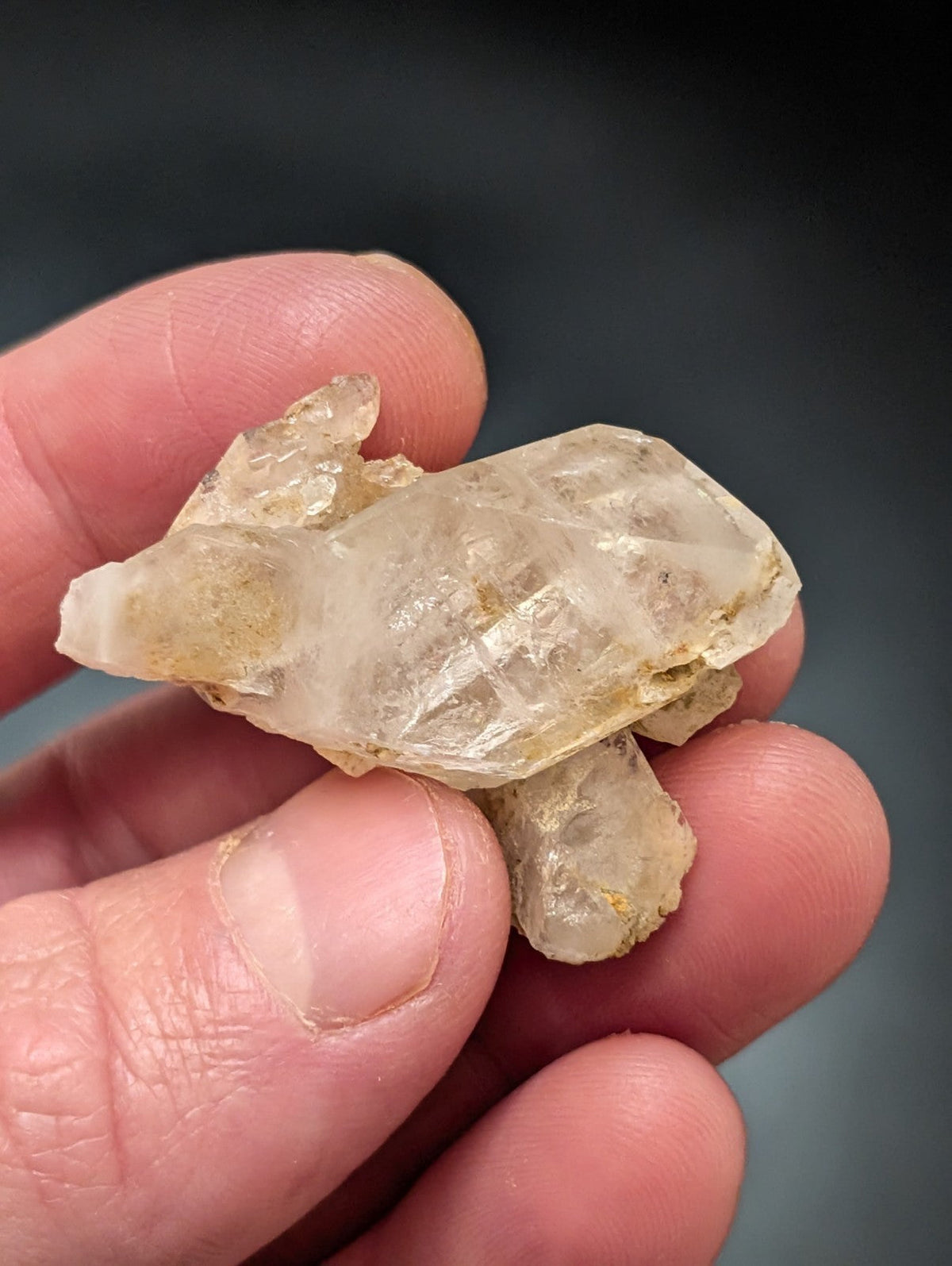A translucent, pale yellowish quartz crystal formation with visible internal striations and a rough, natural surface.