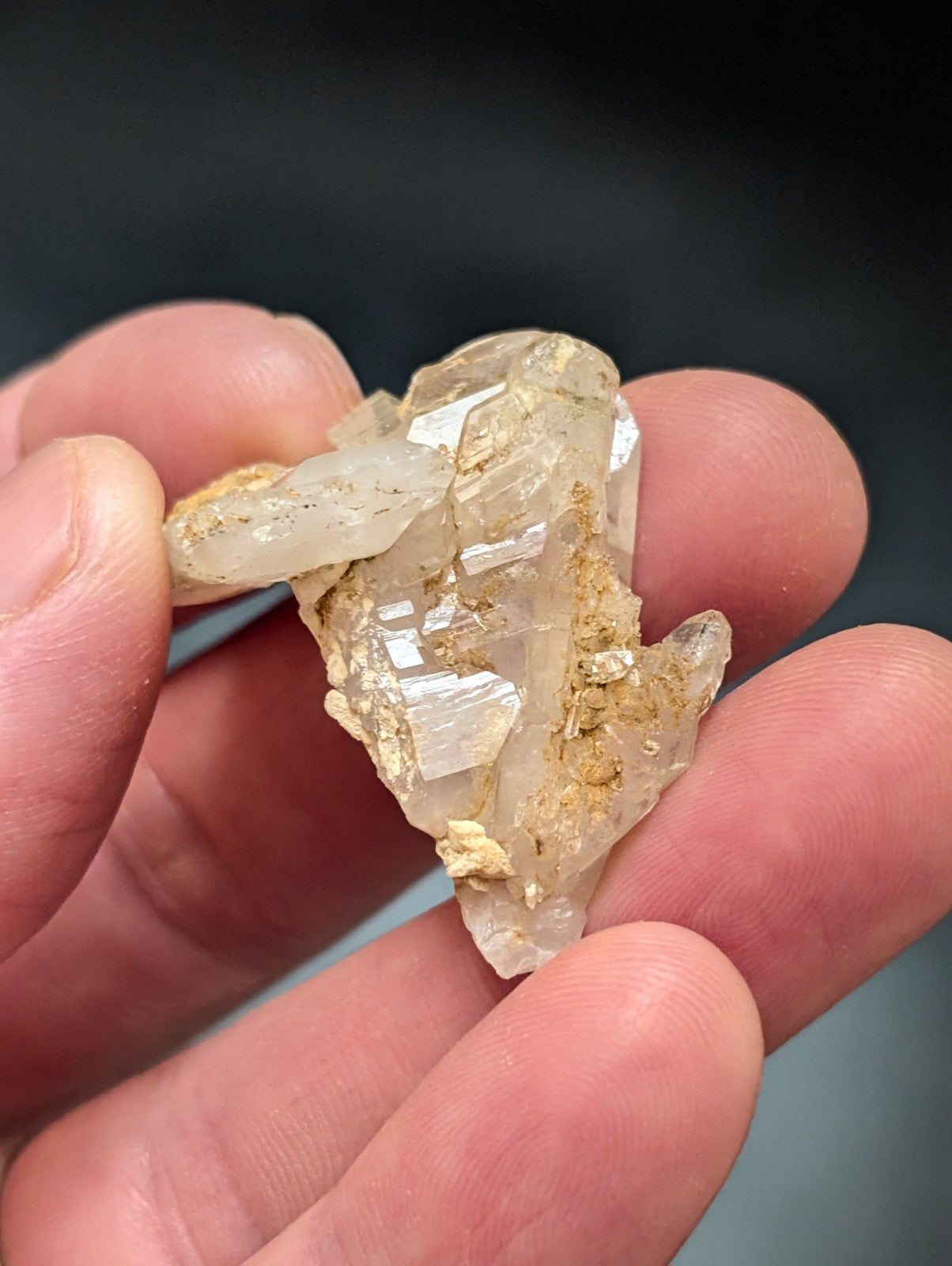 A translucent, pale quartz crystal cluster with golden mineral inclusions.