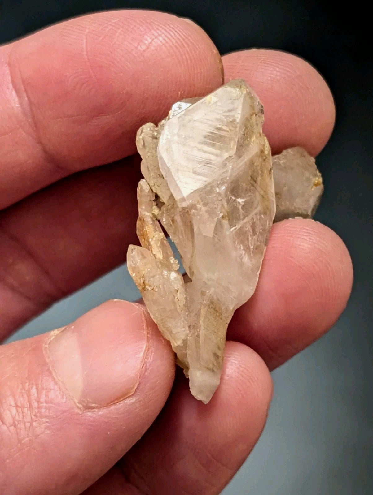 A translucent, pale yellowish quartz crystal cluster with a rough, natural texture and visible internal striations.