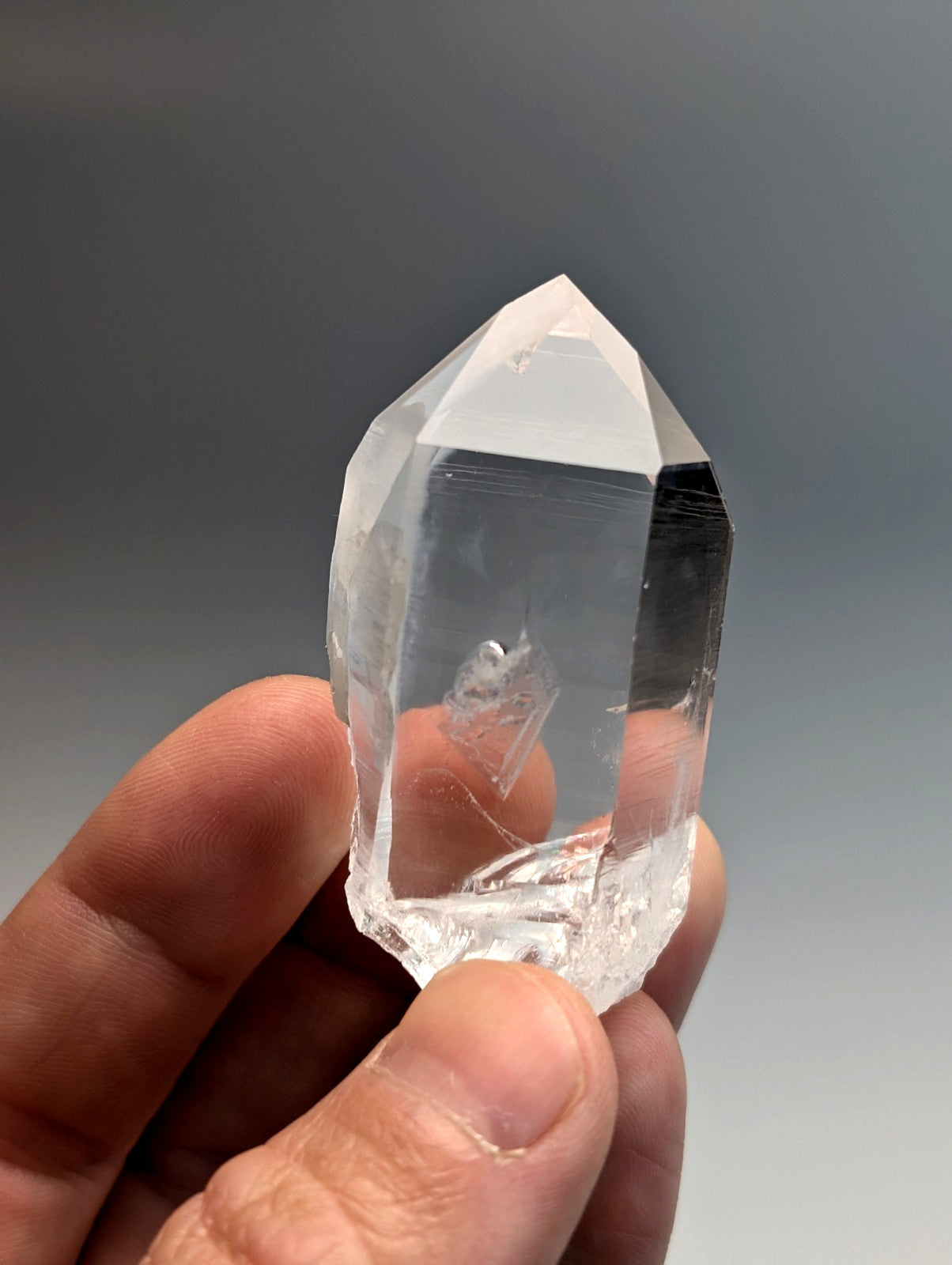Unique quartz crystal point from Arkansas with a clear faceted structure and natural internal inclusions
