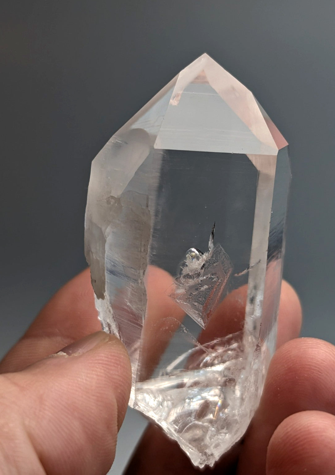 A clear faceted quartz crystal point with pointed tip and natural inclusions from Arkansas usa old stock A+ quality