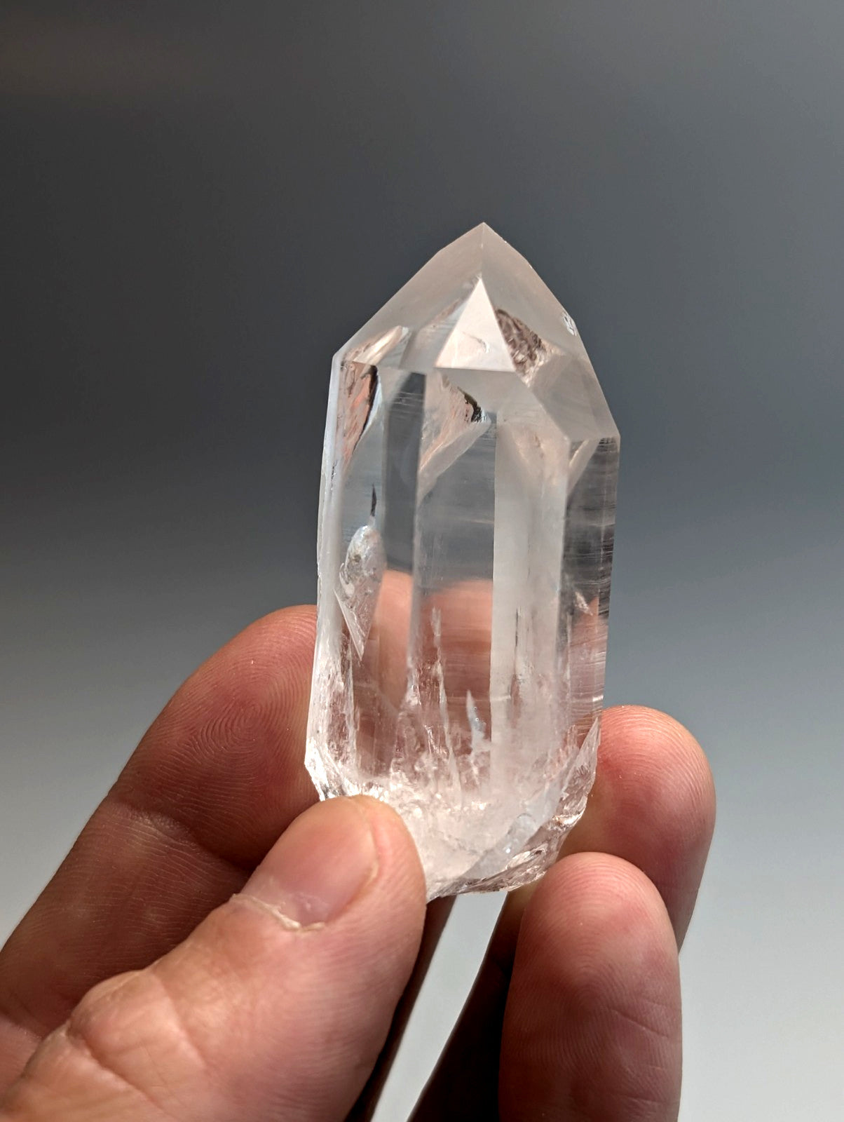 A clear, transparent quartz crystal point with faceted sides from old stock in arkansas usa, a+, water clear