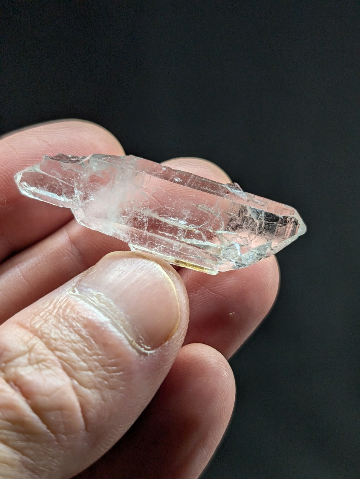 A translucent, clear quartz crystal with natural facets and subtle internal inclusions.