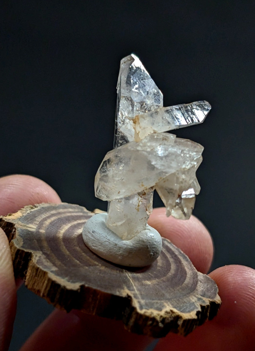 A clear quartz crystal cluster with sharp, translucent facets and a natural, earthy base.