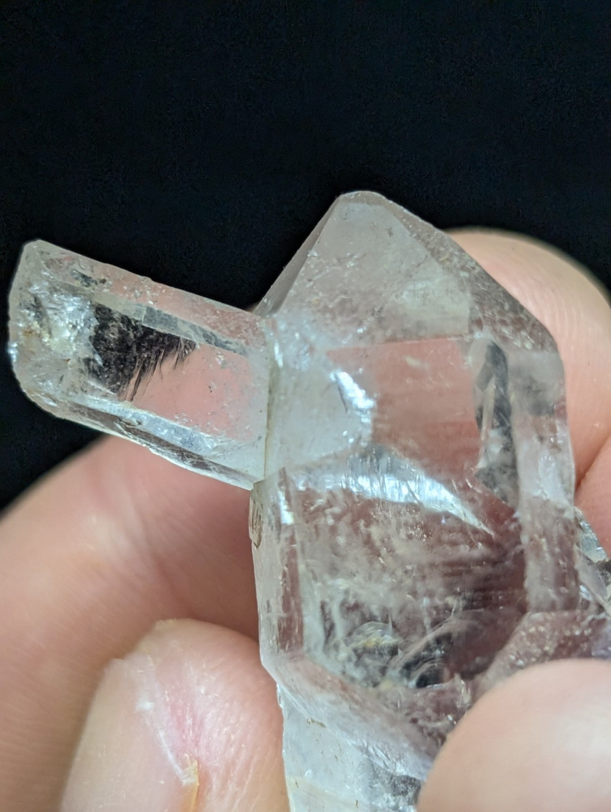 A clear, translucent quartz crystal with angular facets and internal inclusions.