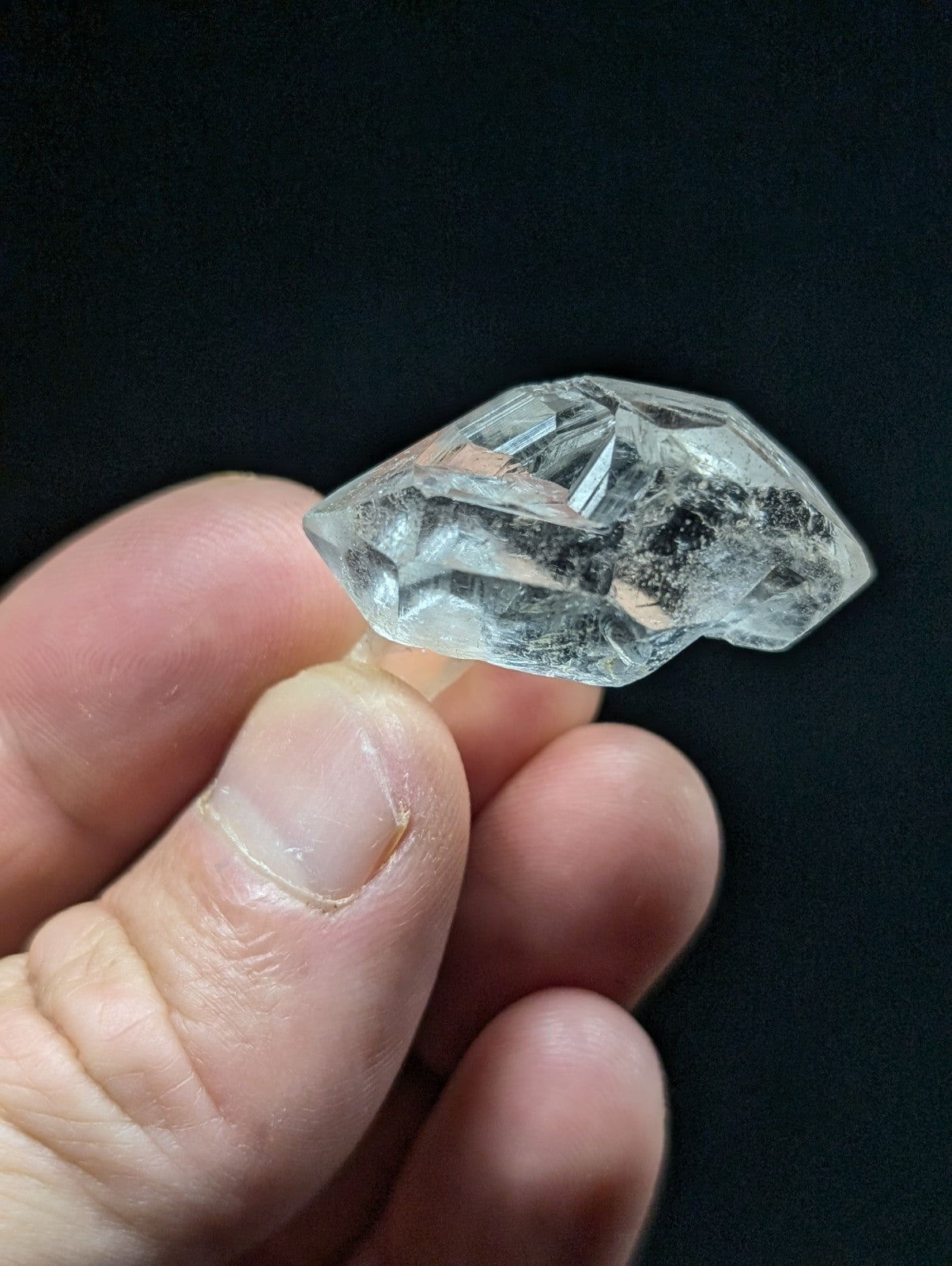 A clear, faceted quartz crystal with natural inclusions and a polished cut.