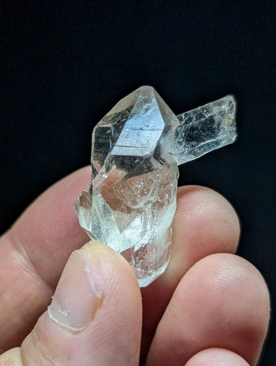 A clear, translucent quartz crystal cluster with sharp geometric facets and a natural, unpolished appearance.