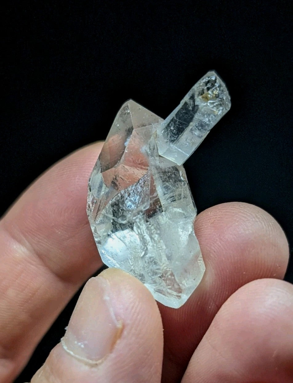 A clear, faceted quartz crystal with a natural, irregular shape and subtle internal inclusions.