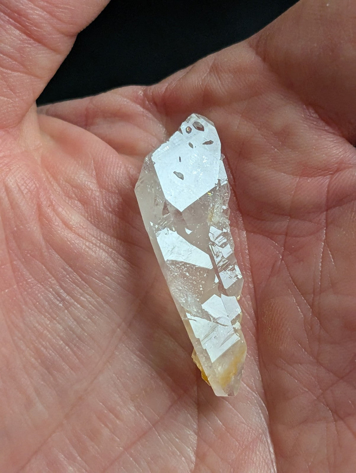 A translucent, clear quartz crystal with a pointed tip and visible internal inclusions.