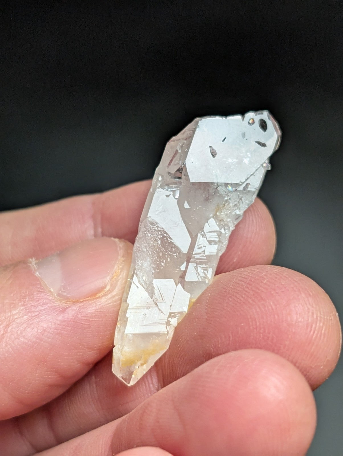 A translucent, clear quartz crystal with a pointed tip and natural facets.
