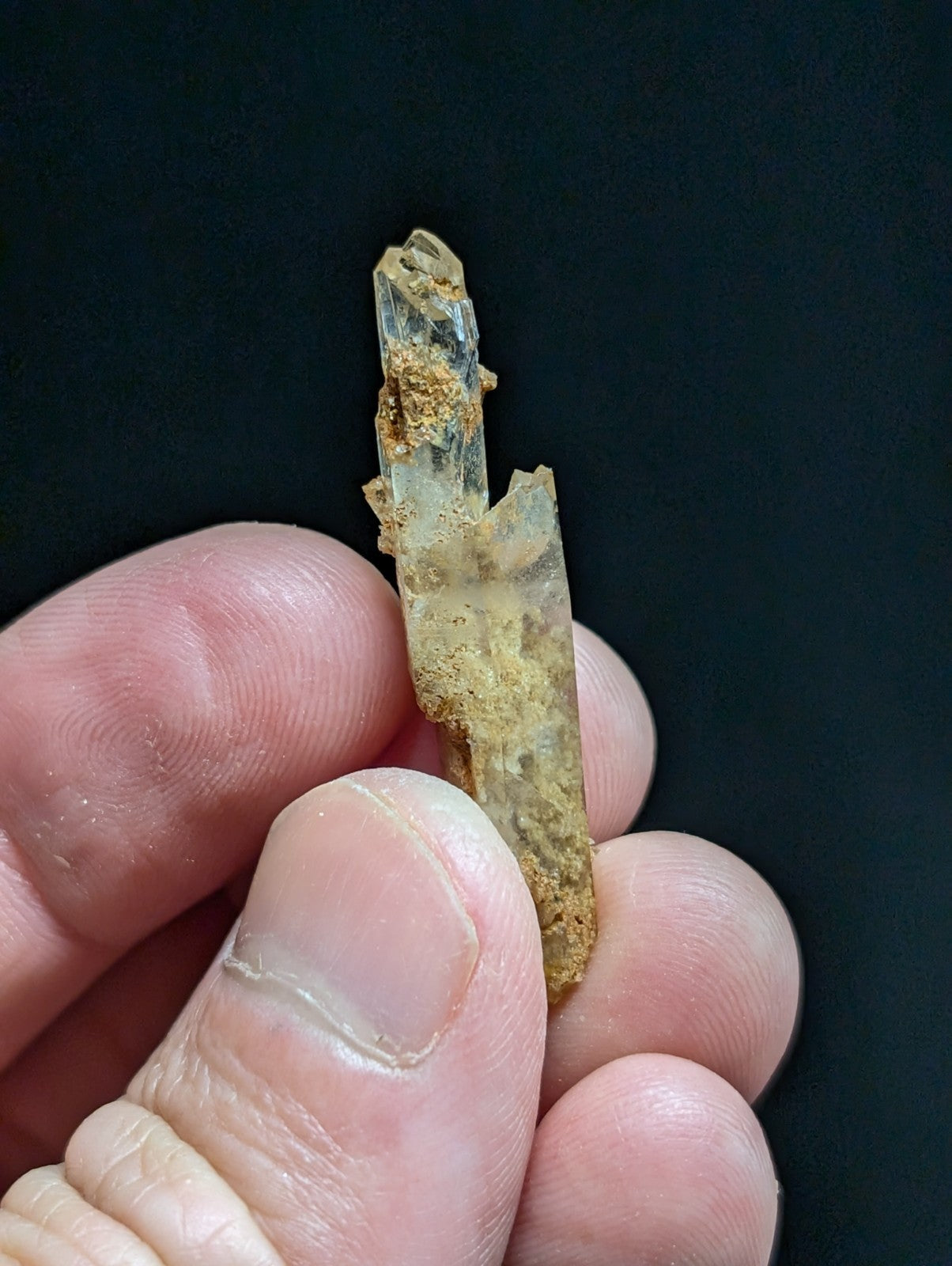A translucent, amber-hued crystal with a rough, jagged surface and visible internal inclusions.