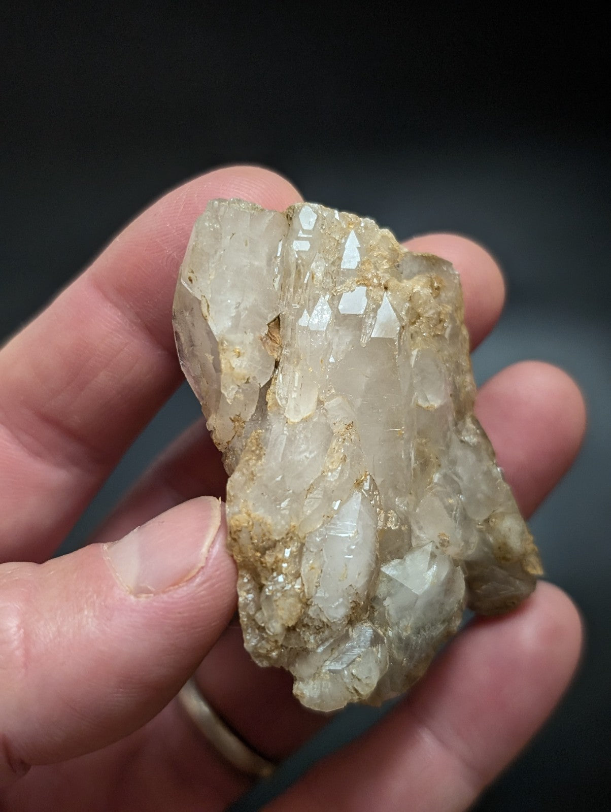 A translucent, pale quartz crystal cluster with golden mineral inclusions.