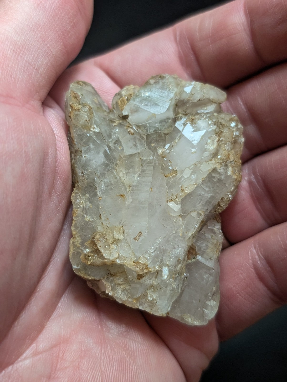 A translucent, pale quartz crystal cluster with jagged edges and golden mineral inclusions.