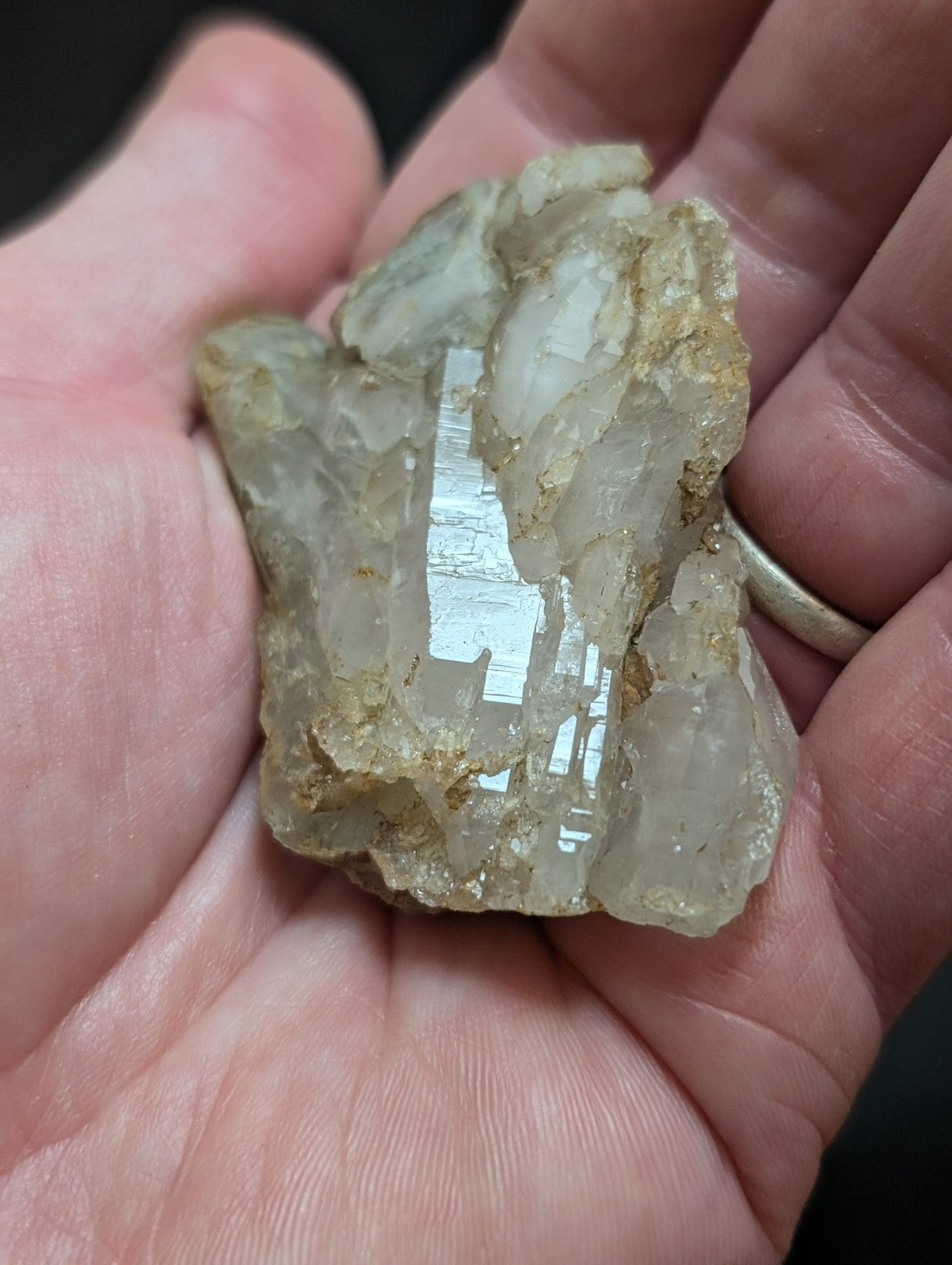 A translucent, pale quartz crystal cluster with rough, jagged edges and golden mineral inclusions.