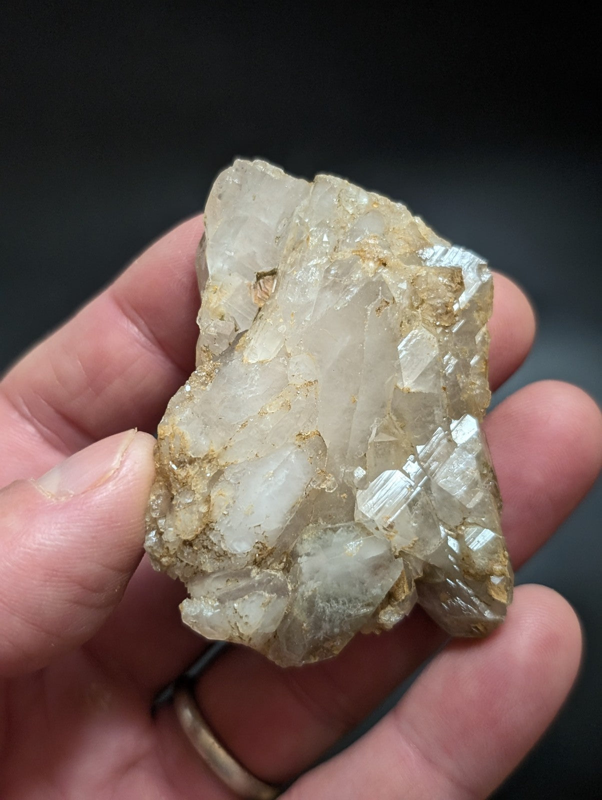A translucent, crystalline quartz cluster with a mix of clear and milky white facets, embedded in a rough, earthy matrix.