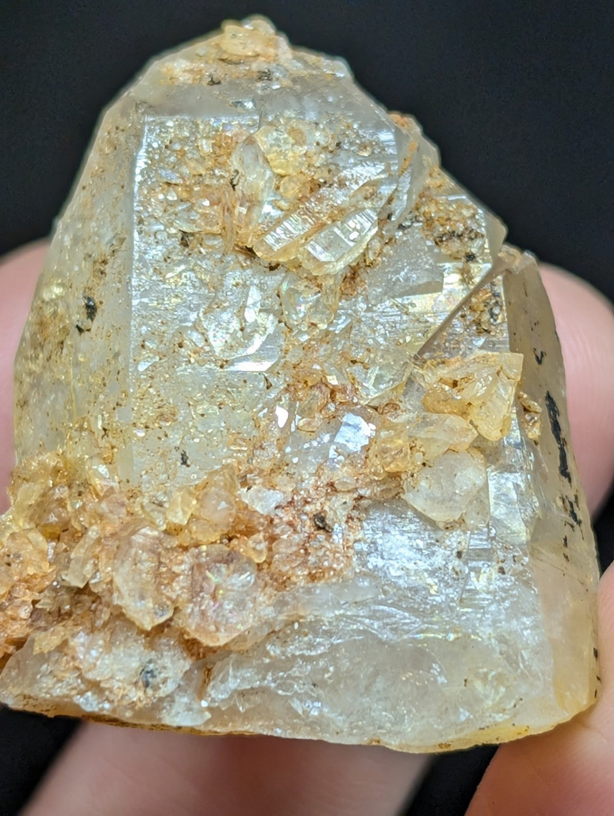 A translucent, pale yellowish quartz crystal with golden mineral inclusions and a rough, natural surface.