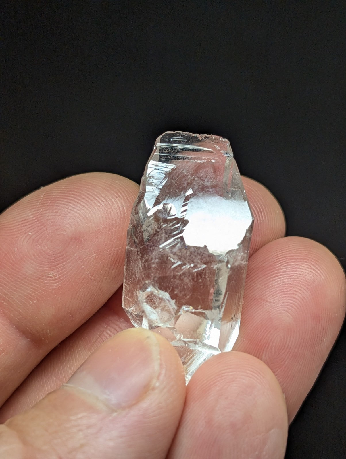 A clear, faceted quartz crystal with natural imperfections and a translucent appearance.