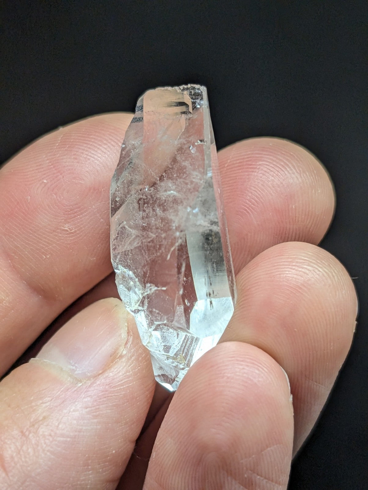 A clear, translucent quartz crystal with natural facets and internal inclusions.