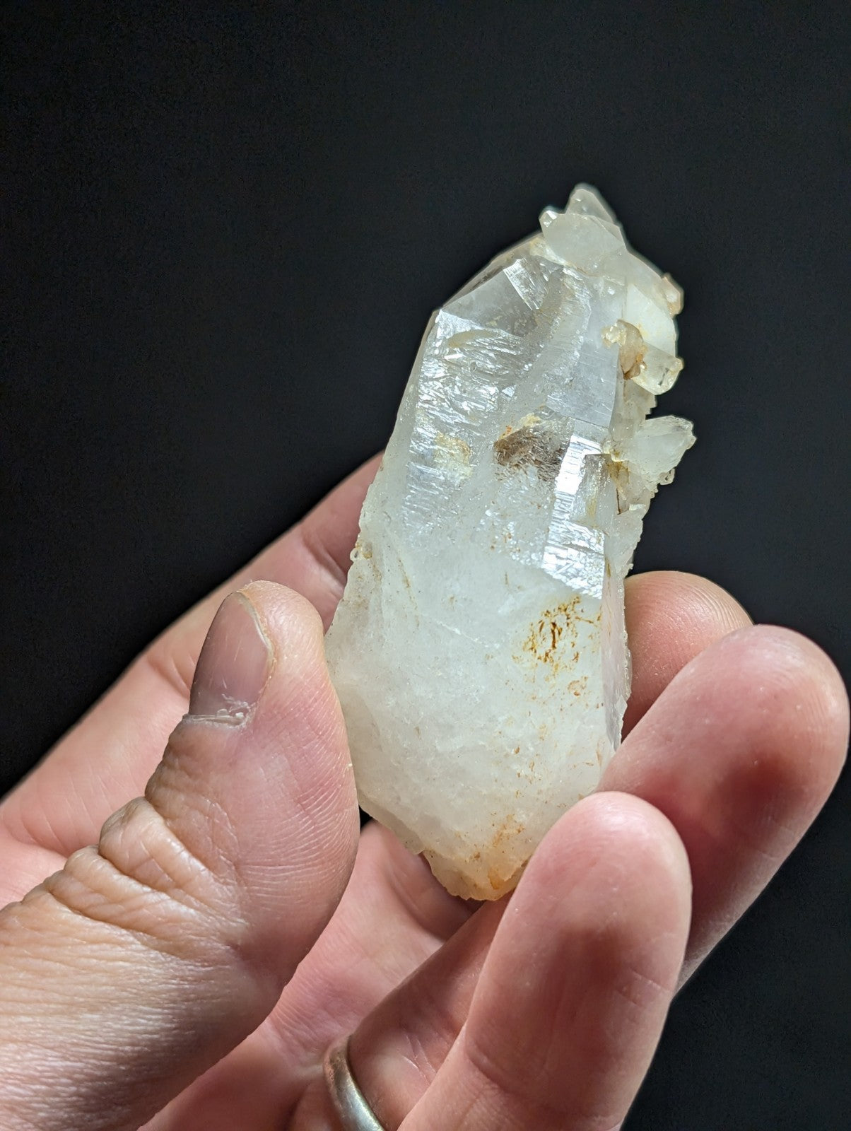 A translucent, pale quartz crystal with natural facets and subtle golden inclusions.